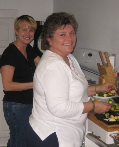 Lizzy Strain Bobbitt and Beth Floyd Delozier assemble skewers for the grill